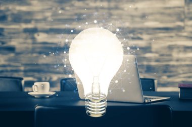 Bilgisayar ofisinde ampul simgesi hologramıyla birlikte. Çifte maruziyet. Fikir kavramı.