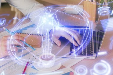 Bilim hologramı, arka planda bilgisayarla çalışan bir adam. Öğrenim anlayışı. Çift pozlama.