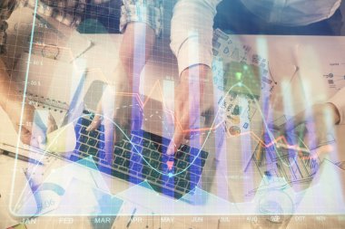 Kadın ve erkeğin birlikte çalıştığı çoklu pozlama ve grafik hologramı çizimi. Finansal analiz konsepti. Bilgisayar arkaplanı. Üst Görünüm.