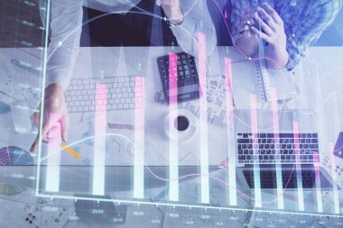 Kadın ve erkeğin birlikte çalışması ve finansal grafik hologramı çizimi. Pazar analizi konsepti. Bilgisayar arkaplanı. Üst Görünüm.