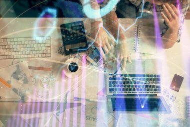 Kadın ve erkeğin birlikte çalışması ve finansal grafik hologramı çizimi. Pazar analizi konsepti. Bilgisayar arkaplanı. Üst Görünüm.
