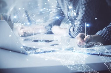 Arkaplanda bilgisayar üzerinde çalışan bir iş adamıyla zarf hologramı çizimi. Elektronik posta konsepti. Çift pozlama.