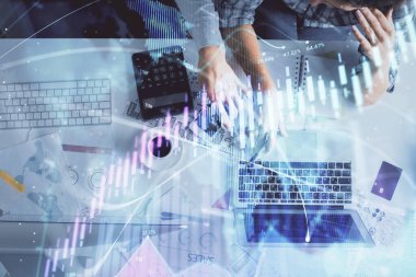Kadın ve erkeğin birlikte çalışması ve finansal grafik hologramı çizimi. Pazar analizi konsepti. Bilgisayar arkaplanı. Üst Görünüm.