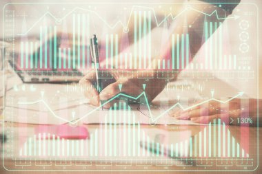 Bilgisayarda ve finansal grafik hologramında yazı yazan kadın ellerine çok maruz kalmış. Borsa analizi kavramı.