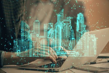 Arka planda bilgisayar üzerinde çalışan bir iş adamı ile yüksek teknoloji şehir çizimi. Akıllılık konsepti. Çift pozlama.