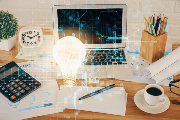 Computer on desktop in office with bulb icon hologram. Double exposure. Concept of idea. — Stock Photo, Image