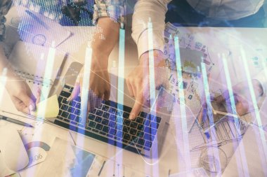 Kadın ve erkeğin birlikte çalıştığı çoklu pozlama ve grafik hologramı çizimi. Finansal analiz konsepti. Bilgisayar arkaplanı. Üst Görünüm.