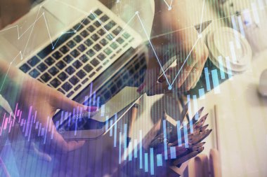 İşkadını ellerinin bilgisayar ve finansal grafik hologramı çizimlerinde çifte pozlama. Borsa analizi kavramı.