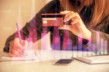 Çevrimiçi alışveriş yapan bir kadının elinde kredi kartı ve mali grafik çizimi tutarken iki kez görüntülenmiş. Borsa E-ticaret kavramı.