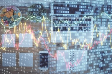 Borsa grafiği ve masa arkasındaki en üst görünüm bilgisayarı. Çoklu maruz kalma. Finansal eğitim kavramı.