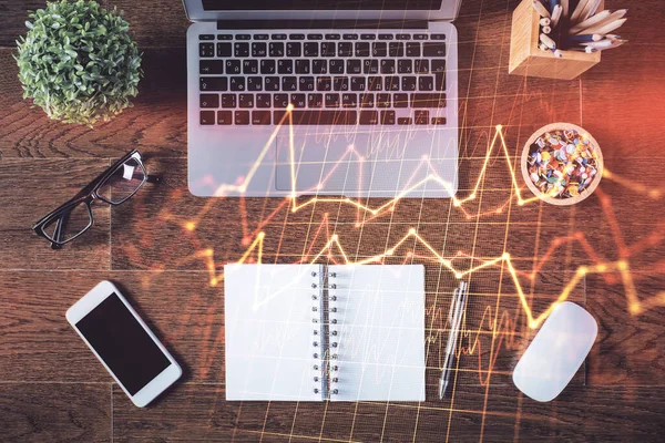 Borsa grafiği ve masa arkasındaki en üst görünüm bilgisayarı. Çoklu maruz kalma. Finansal eğitim kavramı.