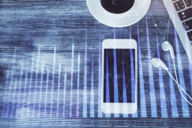 Masaüstünde telefonlu ön x grafik hologramına çift pozlama. Üst Manzara. Mobil ticaret platformu kavramı.