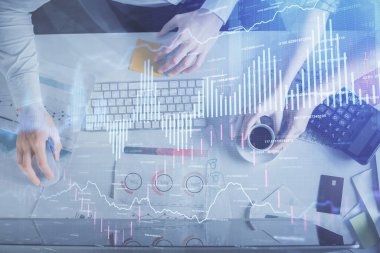 Birlikte çalışan kadın ve erkeğin çifte pozu ve finansal grafik hologramı çizimi. Pazar analizi konsepti. Bilgisayar arkaplanı. Üst Görünüm.