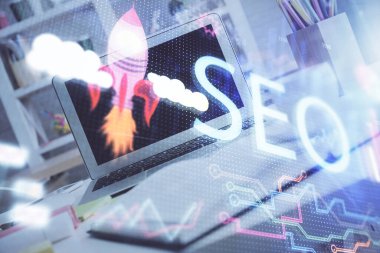 Bilgisayar ve seo çizim hologramı olan bir masanın çifte görüntüsü. Arama optimizasyon kavramı.