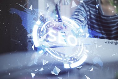 Kadın elinin SEO simgesiyle notlar alırken çoklu pozlanması. Arama motoru optimizasyonu kavramı