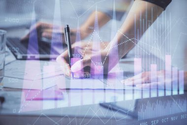 Bilgisayarda ve finansal grafik hologramında yazı yazan kadın ellerine çok maruz kalmış. Borsa analizi kavramı.