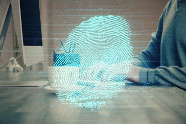 Arka planda bilgisayar üzerinde çalışan iş adamı ile parmak izi hologramı. Güvenlik kavramı. Çift pozlama.