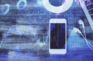 Masaüstünde telefonlu ön x grafik hologramına çift pozlama. Üst Manzara. Mobil ticaret platformu kavramı.