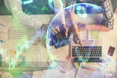 Kadın ve erkeğin birlikte çalışması ve finansal grafik hologramı çizimi. Pazar analizi konsepti. Bilgisayar arkaplanı. Üst Görünüm.