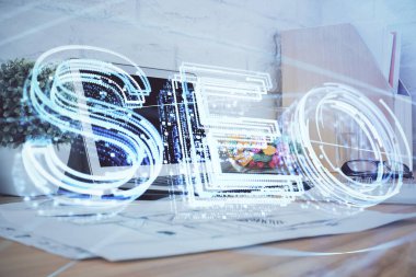 Bilgisayar ve seo çizim hologramı olan bir masanın çifte görüntüsü. Arama optimizasyon kavramı.