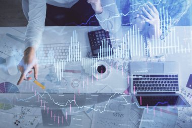 Kadın ve erkeğin birlikte çalışması ve finansal grafik hologramı çizimi. Pazar analizi konsepti. Bilgisayar arkaplanı. Üst Görünüm.