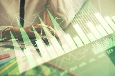 Bilgisayarda ve finansal grafik hologramında kadın eli yazarken çift pozlama. Borsa analizi kavramı.
