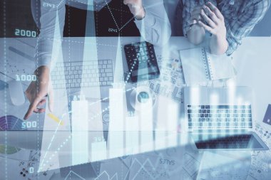 Kadın ve erkeğin birlikte çalışması ve finansal grafik hologramı çizimi. Pazar analizi konsepti. Bilgisayar arkaplanı. Üst Görünüm.