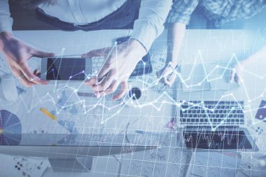 Birlikte çalışan kadın ve erkeğin çifte pozu ve finansal grafik hologramı çizimi. Pazar analizi konsepti. Bilgisayar arkaplanı. Üst Görünüm.