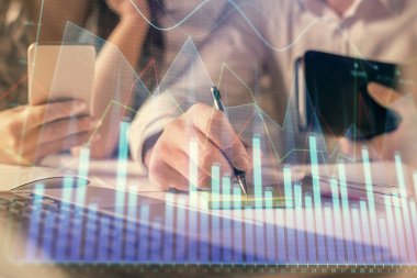 Kadın ve erkeğin birlikte çalışması ve finansal grafik hologramı. İş konsepti. Bilgisayar arkaplanı.