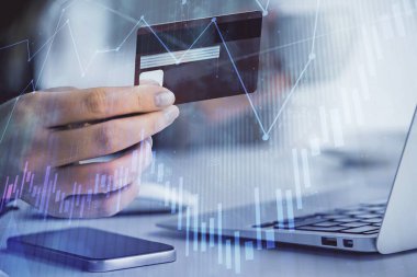 İnternetten alışveriş yapan kadının elinde kredi kartı ve mali grafik çizimi var. Borsa E-ticaret kavramı.