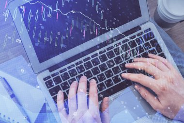 Erkeklerin ellerinin bilgisayar klavyesini ve ön grafik hologram çizimlerini yazarken çifte pozlama. Üst Manzara. Finans piyasası kavramı.