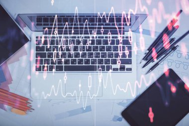 Forx grafiğinin bilgisayar ile masa arkaplanının üzerine çizimi. Finansal araştırma ve analiz kavramı. Üst görünüm.