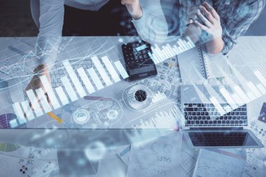 Kadın ve erkeğin birlikte çalışması ve finansal grafik hologramı çizimi. Pazar analizi konsepti. Bilgisayar arkaplanı. Üst Görünüm.