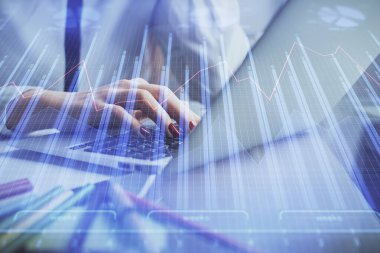 Bilgisayarda ve finansal grafik hologramında kadın eli yazarken çift pozlama. Borsa analizi kavramı.