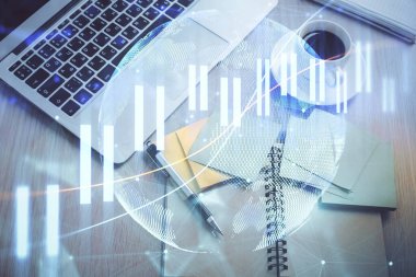 Borsa grafiği ve masa arkasındaki en üst görünüm bilgisayarı. Çifte maruziyet. Finansal eğitim kavramı.