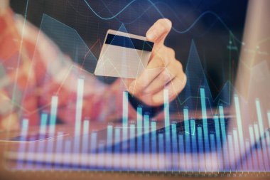 Ellerinde kredi kartı ve forex çizimi olan bir adamın çift pozu. İnternet E-ticaret kavramında hisse senedi ve dijital fintech.