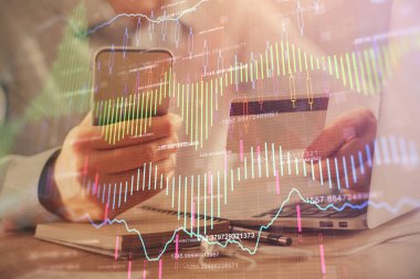 Ellerinde kredi kartı ve forex çizimi olan bir adamın çift pozu. İnternet E-ticaret kavramında hisse senedi ve dijital fintech.