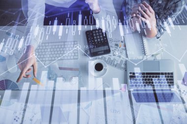 Kadın ve erkeğin birlikte çalışması ve finansal grafik hologramı çizimi. Pazar analizi konsepti. Bilgisayar arkaplanı. Üst Görünüm.