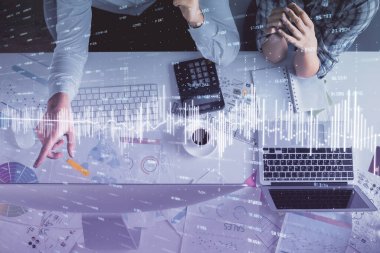 Kadın ve erkeğin birlikte çalışması ve finansal grafik hologramı çizimi. Pazar analizi konsepti. Bilgisayar arkaplanı. Üst Görünüm.