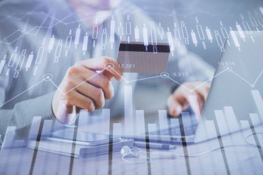 Ellerinde kredi kartı ve forex çizimi olan bir adamın çift pozu. İnternet E-ticaret kavramında hisse senedi ve dijital fintech.