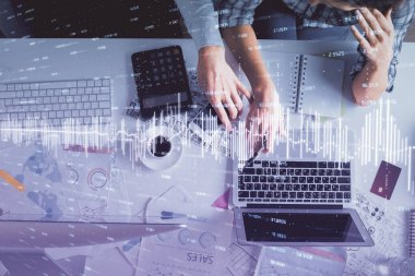 Kadın ve erkeğin birlikte çalışması ve finansal grafik hologramı çizimi. Pazar analizi konsepti. Bilgisayar arkaplanı. Üst Görünüm.