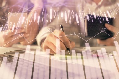 Kadın ve erkeğin birlikte çalışması ve finansal grafik hologramı. İş konsepti. Bilgisayar arkaplanı.