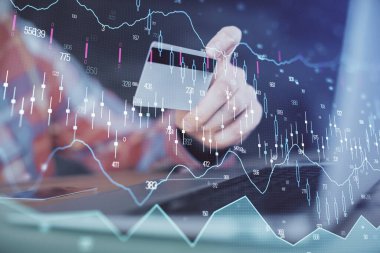 Ellerinde kredi kartı ve forex çizimi olan bir adamın çift pozu. İnternet E-ticaret kavramında hisse senedi ve dijital fintech.