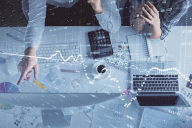 Kadın ve erkeğin birlikte çalışması ve finansal grafik hologramı çizimi. Pazar analizi konsepti. Bilgisayar arkaplanı. Üst Görünüm.