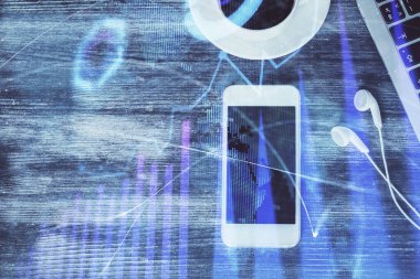 Masaüstünde telefonlu ön x grafik hologramına çift pozlama. Üst Manzara. Mobil ticaret platformu kavramı.