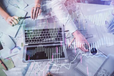 Kadın ve erkeğin birlikte çalışması ve finansal grafik hologramı. İş konsepti. Bilgisayar arkaplanı.