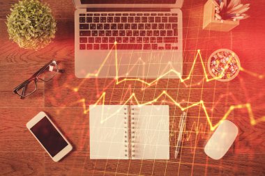 Borsa grafiği ve masa arkasındaki en üst görünüm bilgisayarı. Çoklu maruz kalma. Finansal eğitim kavramı.