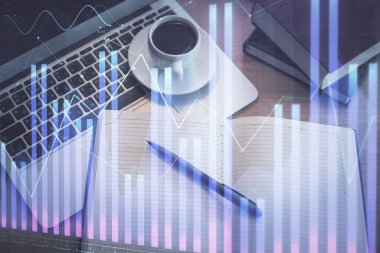 Borsa grafiği ve masa arkasındaki en üst görünüm bilgisayarı. Çoklu maruz kalma. Finansal eğitim kavramı.