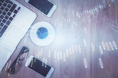 Masaüstü üzerinde telefonla finansal haritaya çoklu maruz kalma. Üst Manzara. Mobil ticaret platformu kavramı.