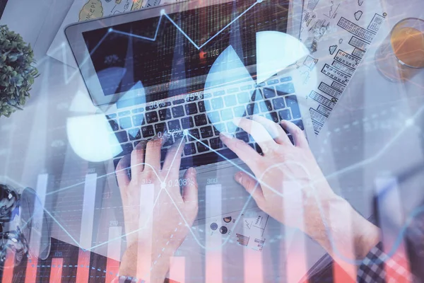 노트북 키보드와 전산 차트 홀로그램 그림을 통해 타자를 치는 사람들의 손 이 두 번 노출되었다. 위에서 본 모습. 금융 시장의 개념. — 스톡 사진